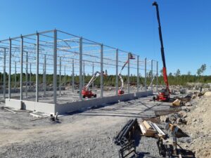 Rakennusvaiheessa oleva hallin runko ja muutamia rakennustyökoneita.